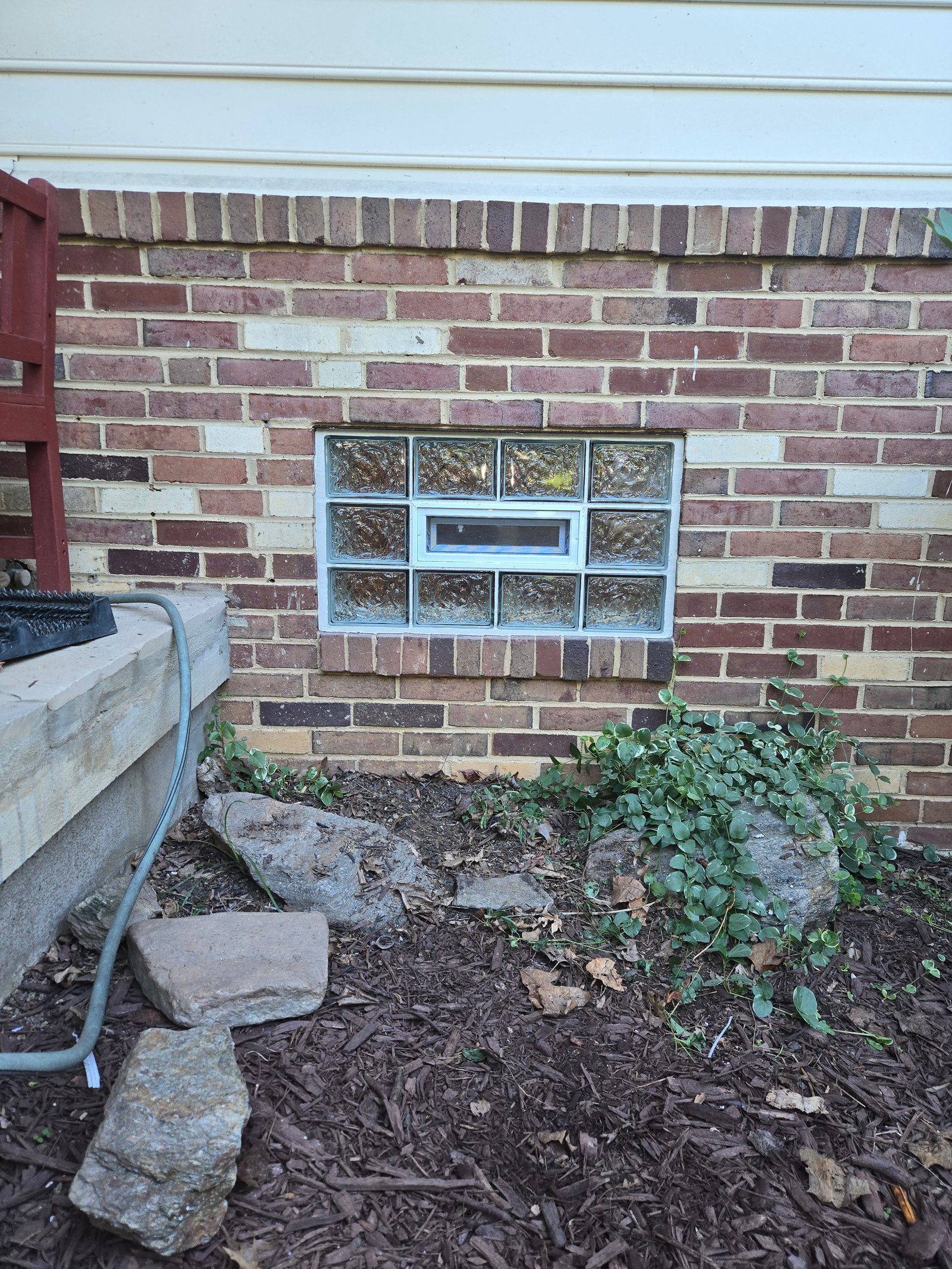 Glass block basement window with vent in brick